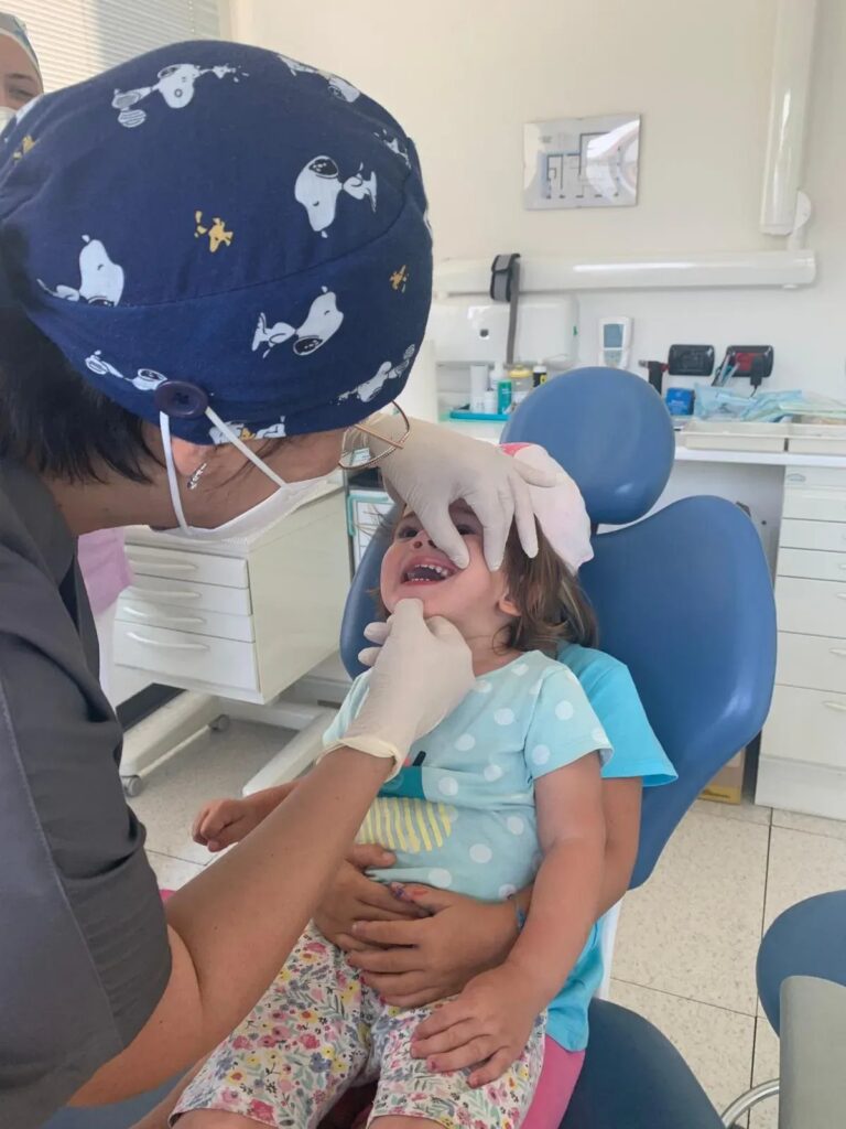 Bambina sorridente sulla poltrona durante la visita pediatrica